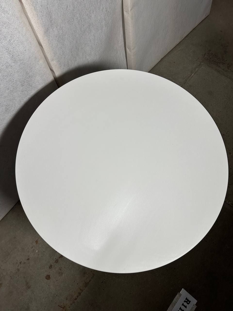 Moderne rundt bord med hvit topp og svart metallbase