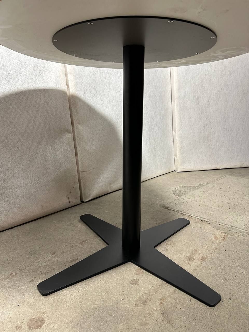 Moderne rundt bord med hvit topp og svart metallbase